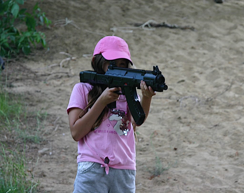 Dziewczyna trzymająca laserowy karabin podczas rozgrywki laser taga